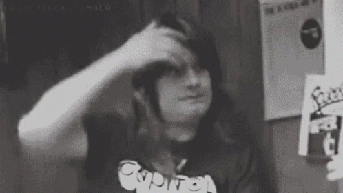 A Black And White Photo Of A Person Scratching Their Head With Their Hand . GIF
