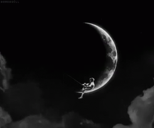 A Black And White Photo Of A Person Sitting On A Swing On A Crescent Moon . GIF