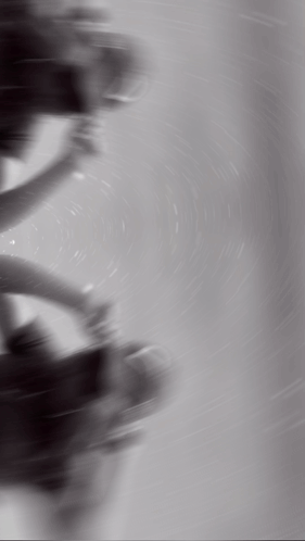 A Black And White Photo Of A Person Spinning A Steering Wheel GIF