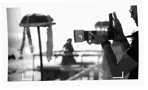 a black and white photo of a person taking a picture with the letter l on the bottom right