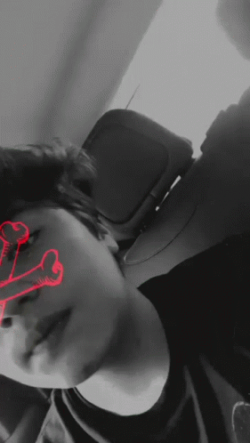 A Black And White Photo Of A Person With A Red Skull In The Background GIF