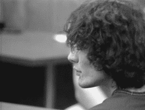 A Black And White Photo Of A Person With Curly Hair . GIF