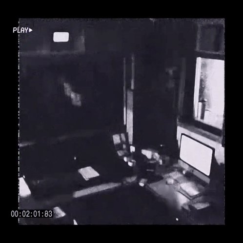 A Black And White Photo Of A Room With A Computer And A Clock GIF