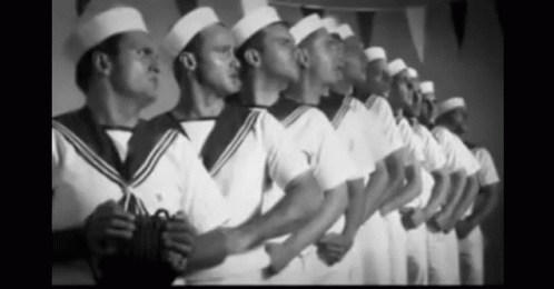 A Black And White Photo Of A Row Of Men In Sailor Uniforms GIF