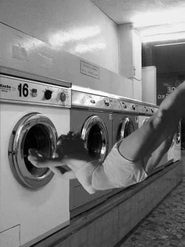 A Black And White Photo Of A Row Of Washing Machines With The Number 16 On Them GIF