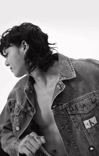 A Black And White Photo Of A Shirtless Man Wearing A Denim Jacket That Says Ck On The Back GIF