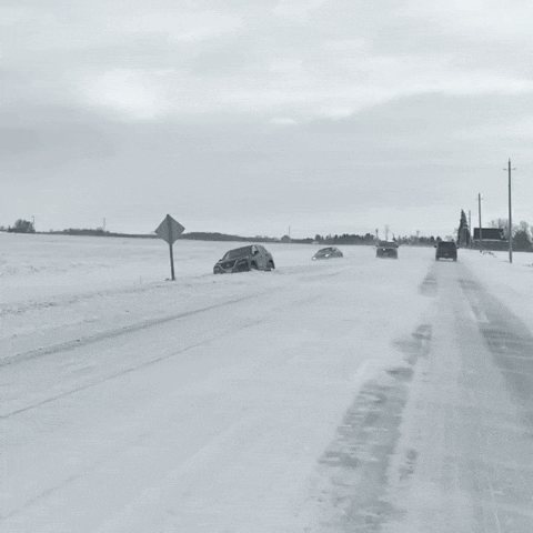 A Black And White Photo Of A Snowy Road With A Police Car In The Background GIF