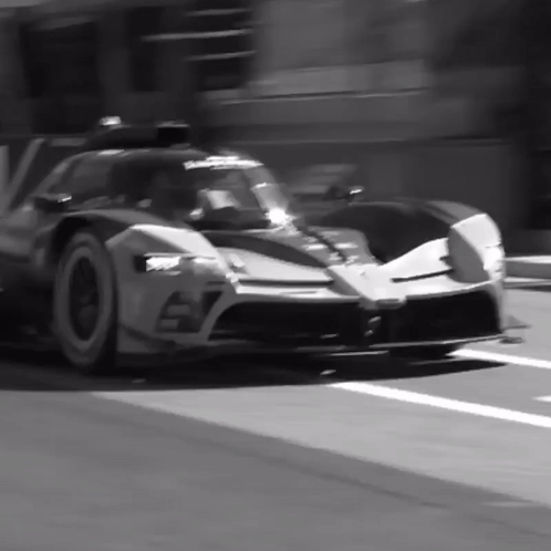 A Black And White Photo Of A Sports Car With The Number 57 On It GIF