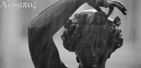 A Black And White Photo Of A Statue Of A Woman With The Letters A And U On The Bottom Right GIF
