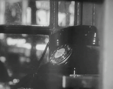 A Black And White Photo Of A Telephone Sitting In A Window GIF