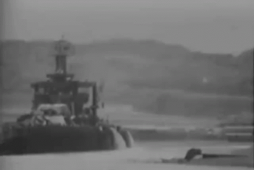a black and white photo of a tug boat in the water .