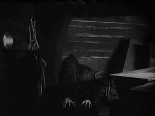A Black And White Photo Of A Vampire With Sharp Claws . GIF