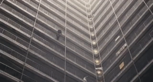 A Black And White Photo Of A Very Tall Building With The Letters Eee On The Side GIF