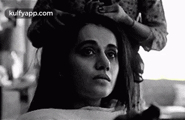 A Black And White Photo Of A Woman Getting Her Hair Done At A Salon . GIF