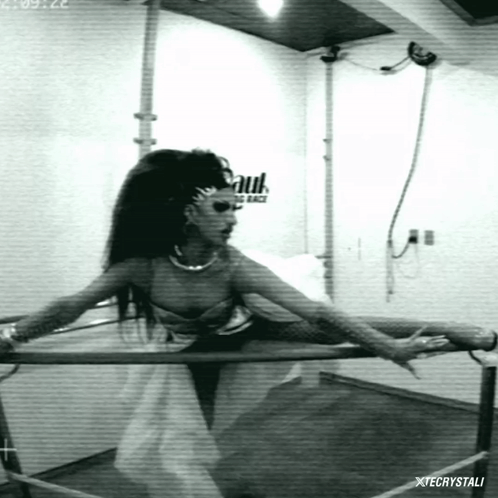 A Black And White Photo Of A Woman Holding A Bar With Xtecrystali Written On The Bottom Right GIF