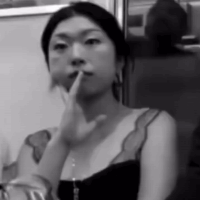 A Black And White Photo Of A Woman Holding Her Finger To Her Lips GIF