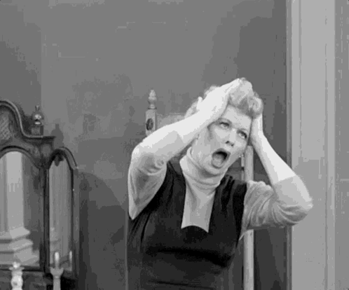 A Black And White Photo Of A Woman Holding Her Head In A Room . GIF