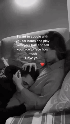 A Black And White Photo Of A Woman Hugging A Man On A Couch .. GIF