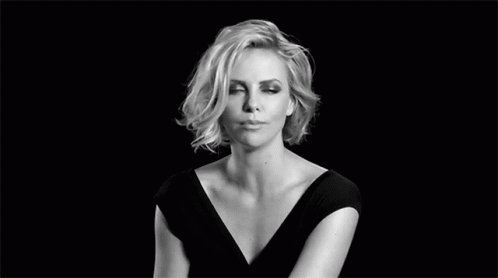 A Black And White Photo Of A Woman In A Black Dress Making A Face . GIF