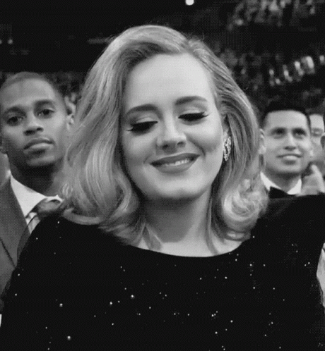 A Black And White Photo Of A Woman In A Black Dress Smiling . GIF
