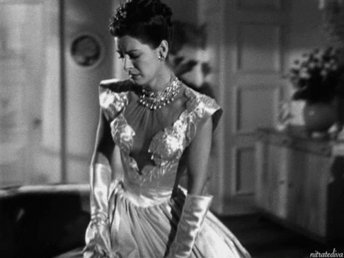 A Black And White Photo Of A Woman In A Dress And Gloves Taken By Nitratediva GIF