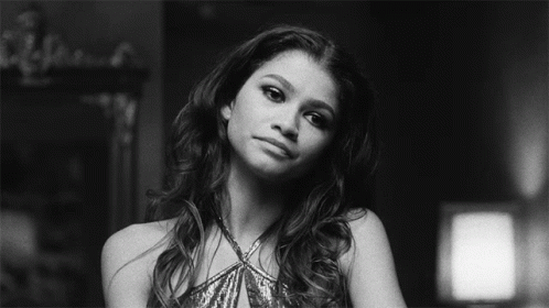 A Black And White Photo Of A Woman In A Sequined Dress Looking At The Camera . GIF