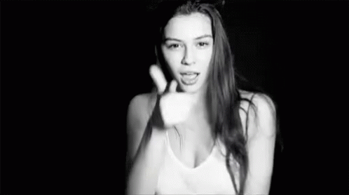 A Black And White Photo Of A Woman In A Tank Top Making A Funny Face . GIF