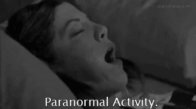 A Black And White Photo Of A Woman Laying In Bed With Her Mouth Open And The Words `` Paranormal Activity '' Below Her . GIF