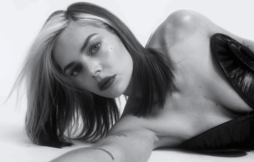 A Black And White Photo Of A Woman Laying On Her Stomach GIF