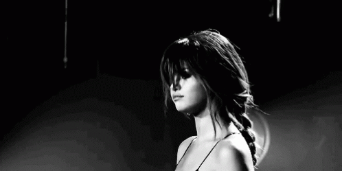 A Black And White Photo Of A Woman Making A Funny Face While Standing On A Stage . GIF