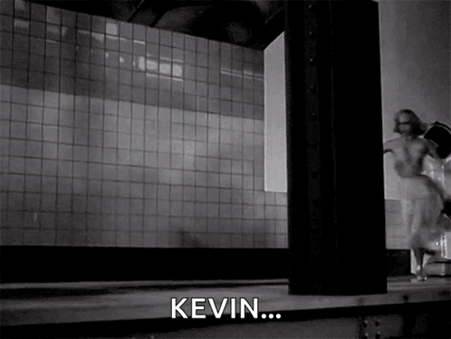 A Black And White Photo Of A Woman Running In A Room With The Word Kevin In The Corner GIF