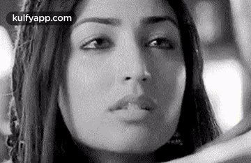 A Black And White Photo Of A Woman 'S Face With A Serious Look On Her Face . GIF