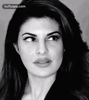 A Black And White Photo Of A Woman 'S Face With A Serious Look On Her Face . GIF