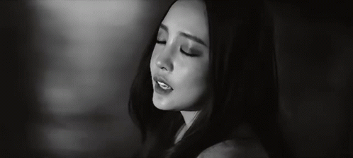 a black and white photo of a woman 's face with her eyes closed .