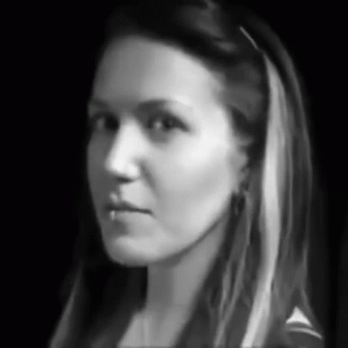 A Black And White Photo Of A Woman 'S Face With Long Hair GIF