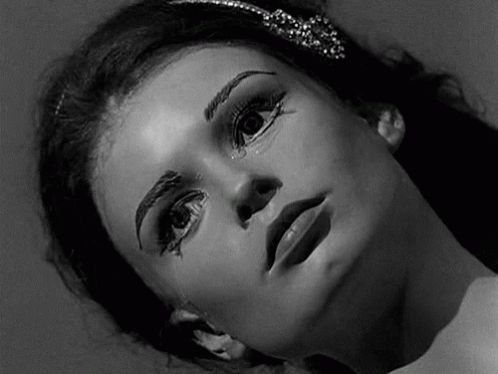 A Black And White Photo Of A Woman 'S Face With Makeup On Her Face . GIF