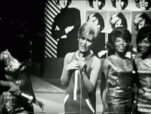 A Black And White Photo Of A Woman Singing Into A Microphone With Mbs Written On The Bottom GIF