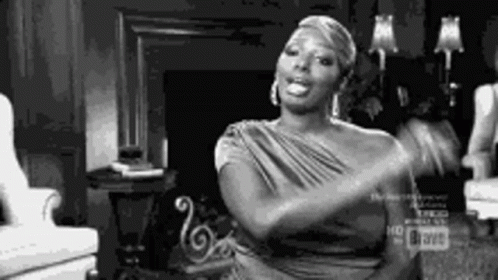 A Black And White Photo Of A Woman Sitting In A Chair . GIF