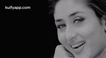 A Black And White Photo Of A Woman Smiling And Looking At The Camera . GIF