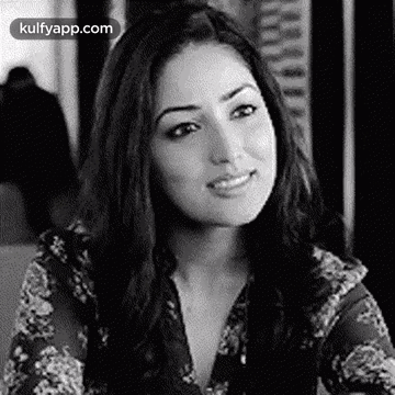 A Black And White Photo Of A Woman Smiling In A Restaurant . GIF