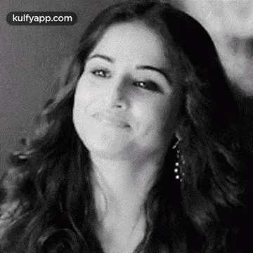 A Black And White Photo Of A Woman Smiling With Her Eyes Closed . GIF