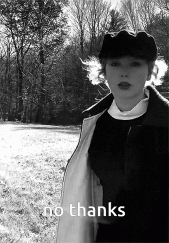 A Black And White Photo Of A Woman Standing In A Field With The Words No Thanks Written Below Her GIF