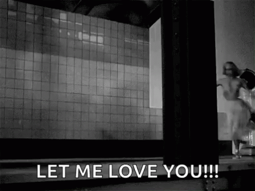 A Black And White Photo Of A Woman Standing In Front Of A Building . GIF
