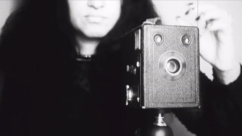 A Black And White Photo Of A Woman Taking A Picture With The Word She Visible GIF