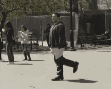 A Black And White Photo Of A Woman Walking Down A Street GIF