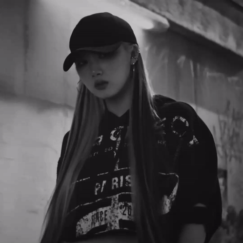 A Black And White Photo Of A Woman Wearing A Hat And A Paris Shirt GIF