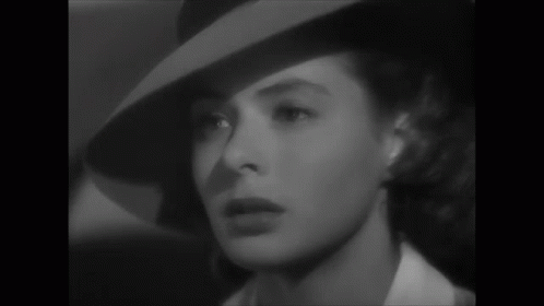 a black and white photo of a woman wearing a hat and a white shirt