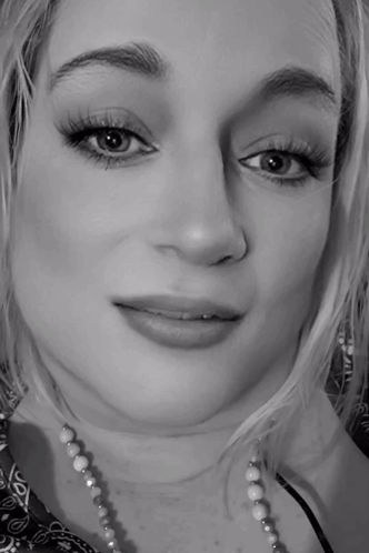 A Black And White Photo Of A Woman Wearing A Necklace GIF