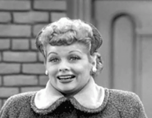 A Black And White Photo Of A Woman Wearing A Sweater And Earrings . GIF