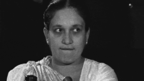A Black And White Photo Of A Woman Wearing A White Shirt GIF